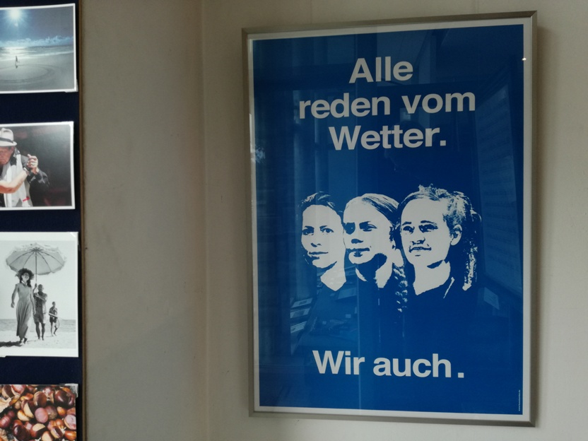 Plakat von AC Klarmann "Alle reden vom Wetter. Wir auch." (blau) Die dargestellten Frauen sind von rechts nach links: Judith Ellens (Sozial-Unternehmerin), Greta Thunberg (Klima-Aktivistin) und Carola Rackete (Kapitänin und Seenotretterin)
Das Plakat ist direkt gerahmt in einem Roggenkamp-Wechselrahmen Alu K natur. (86x61cm)